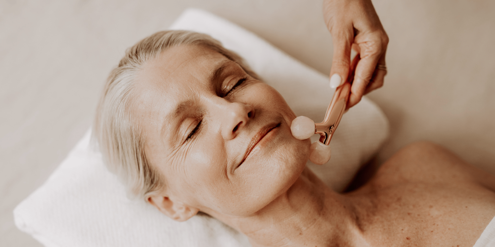 Woman performing lymphatic drainage facial massage at home with natural botanical skincare oil